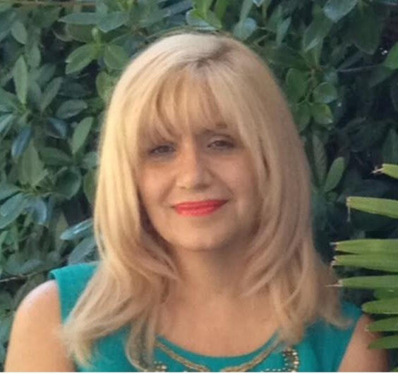 A photo of Dr. Stonbely in front of greenery