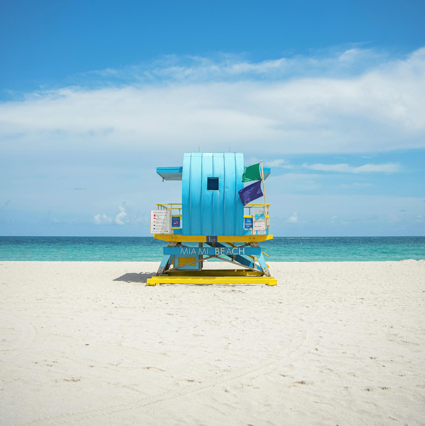 woman on a mountain top overlooking other mountains with her hands up celebrating